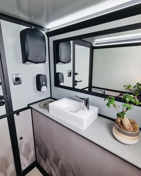 Sink, mirror and soap dispensers inside a restroom trailer