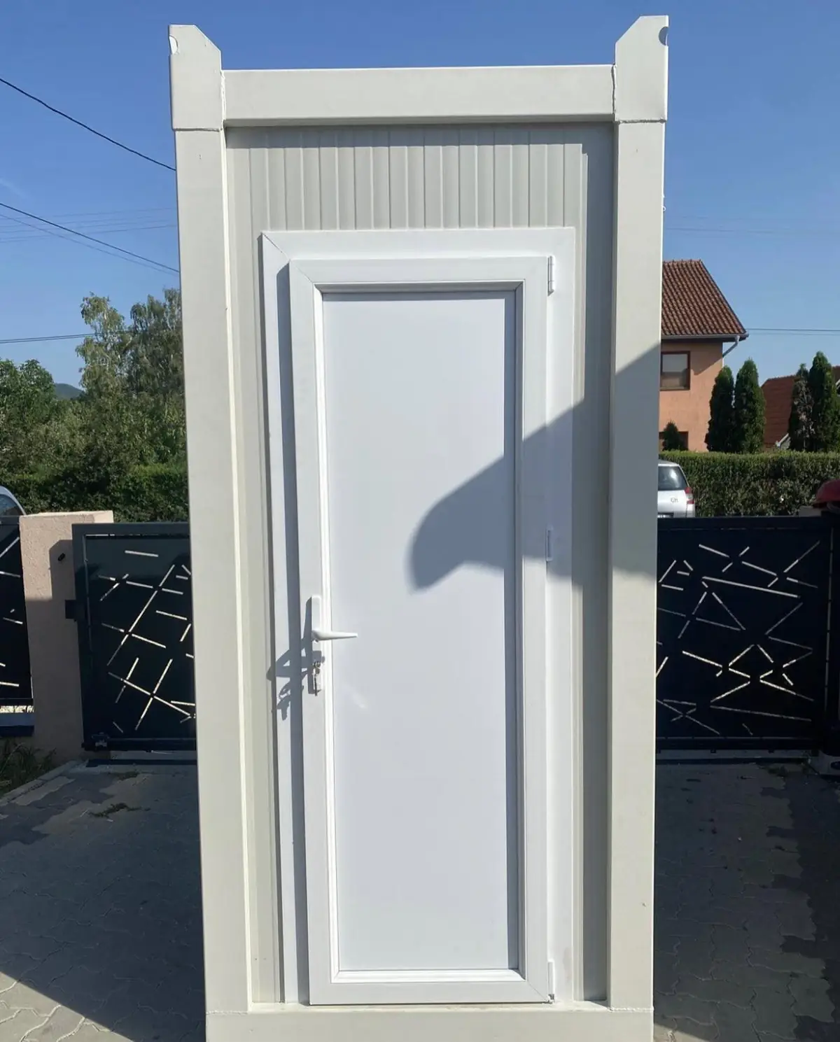 White flushing portable restroom cabin standing on pavement